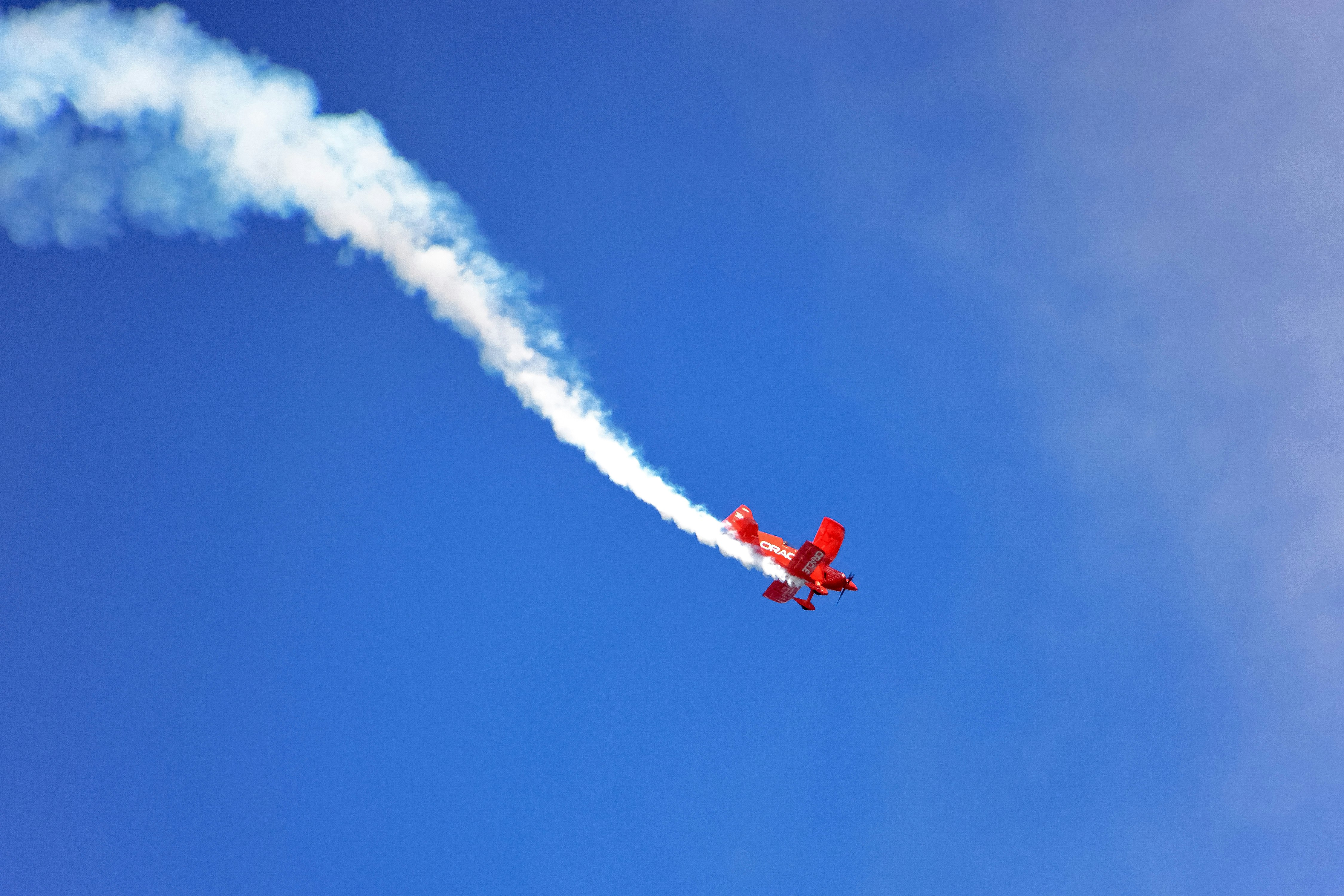 red and white jet plane in mid air